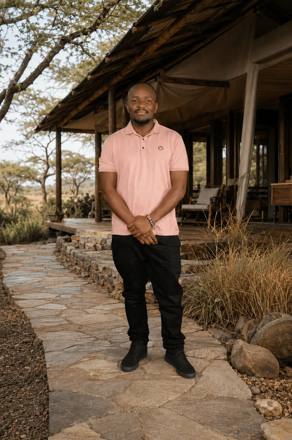 Albert, founder of DiscoverTZ, standing in front of a luxury safari lodge in Tanzania